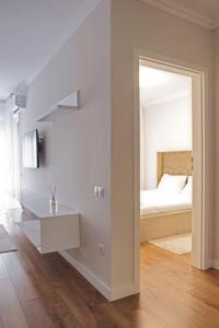ein weißes Zimmer mit einem Bett und einem Spiegel in der Unterkunft 4 Dream Apartmanet 4+parcare gratuita in Oradea