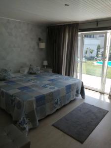ein Schlafzimmer mit einem Bett und einem großen Fenster in der Unterkunft Vivenda Mendes in Outeiro