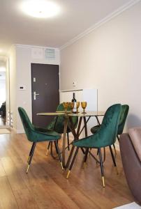 ein Esszimmer mit einem Tisch und grünen Stühlen in der Unterkunft 4 Dream Apartmanet 4+parcare gratuita in Oradea