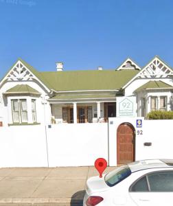 uma casa branca com um carro estacionado em frente dela em Heath Villa - private room em Port Elizabeth