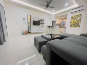 un soggiorno con un divano e una TV di 4 Room Sweet Home 12pax @ Puncak Alam a Kuala Selangor