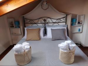 ein Schlafzimmer mit einem großen Bett mit zwei Körben in der Unterkunft Le Camere della Casa di Tessa nel Borgo Antico in Termoli