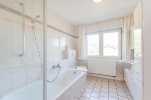 un bagno bianco con vasca e lavandino di Hotel Bamberger Hof, garni a Eisenach Altre 37 foto
