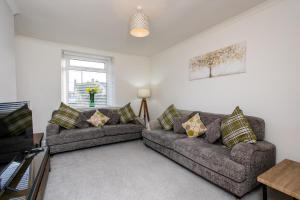 a living room with two couches and a window at Burnside Cottage, Wark, Hexham in Hexham