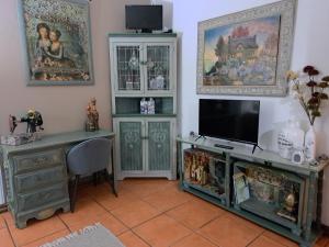 een kamer met een bureau, een tv en een tafel bij LAVENDER AND LACE GUEST FLAT in Pretoria