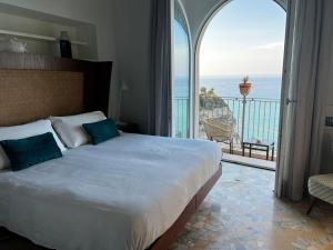 una camera con un grande letto e vista sull'oceano di La Dolce Vita a Tropea a Tropea