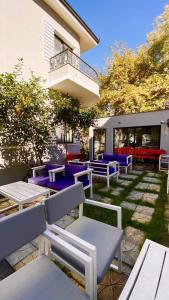a patio with blue and purple benches in front of a building at Hotel Antigone in Tirana