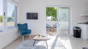 a living room with a blue chair and a table at 34.4 Degrees South Studio Apartment in Agulhas