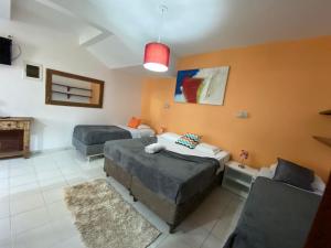 a bedroom with two beds and a couch at Hotel Fênix in Florianópolis