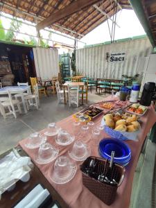 una mesa con vasos y tazones de comida. en Container Eco Suítes, en Cabo Frío