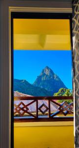 a view of a mountain through a window at Sea Piton View Apartment- Location, Convenience, Modern Living in Soufrière