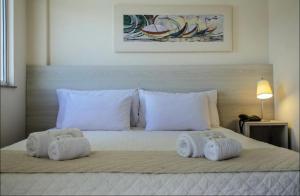 a bedroom with a bed with two towels on it at Loft 319 - INCOMPARÁVEL in Itacuruçá