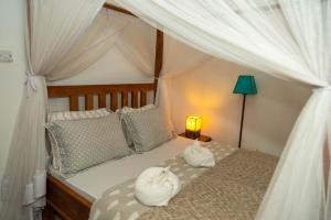 Un dormitorio con una cama con toallas blancas. en Blue elephant villas, en Arusha