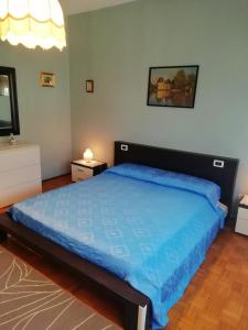 een slaapkamer met een groot bed en een blauw dekbed bij Alloggio Cristina in Valdobbiadene