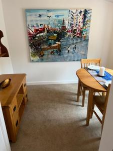 a dining room with a table and a painting on the wall at The Old Dairy Steep,Petersfield in Collyers Estate in the South Downs National park in Petersfield