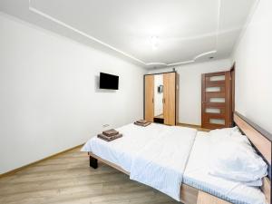a white bedroom with a bed and a tv at Апартаменти по вул Галицька in Ivano-Frankivsʼk