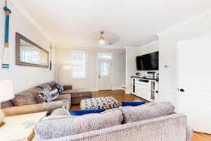 a living room with two couches and a tv at Barefoot Cottages #B8 Jasmine by the Bay in Highland View