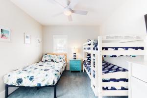 a bedroom with two bunk beds and a ceiling fan at Barefoot Cottages #B8 Jasmine by the Bay in Highland View