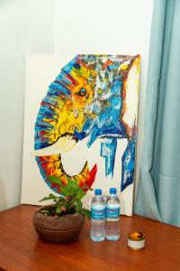 un dipinto di un leone con due bottiglie d'acqua di Blue elephant villas ad Arusha
