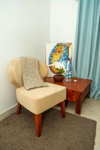 a living room with a chair and a wooden table at Blue elephant villas in Arusha