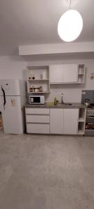 a kitchen with white cabinets and a white refrigerator at Apart Plaza in San Salvador de Jujuy