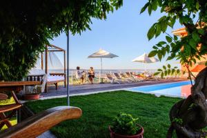 - une piscine avec des chaises et des parasols à côté de l'océan dans l'établissement Agriturismo Paitin, à Alba