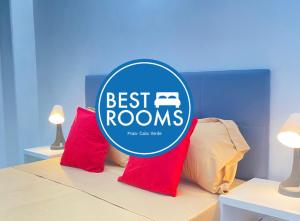 a best rooms sign on a bed with red pillows at Best Rooms- Quarto 4 Plateau in Praia