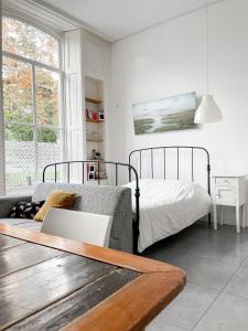 a bedroom with a bed and a table with a laptop at Gastenverblijf De Oare Keamer Kollum Friesland in Kollum