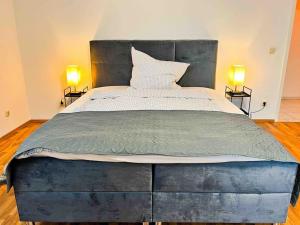 duże łóżko w pokoju z dwoma lampami w obiekcie Qonroom - as individual as you - Wulferdingsen w mieście Bad Oeynhausen