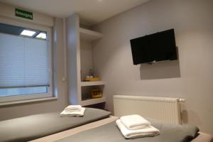 1 Schlafzimmer mit 2 Betten und einem Flachbild-TV in der Unterkunft Pension Sölde in Dortmund