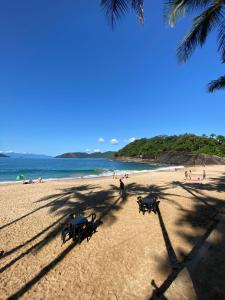 a group of picnic tables on a beach at Pousada Tribo Ubatuba in Ubatuba