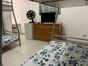 a bedroom with two bunk beds and a television at Pousada Internacional EAS Airport 10min in Guarulhos
