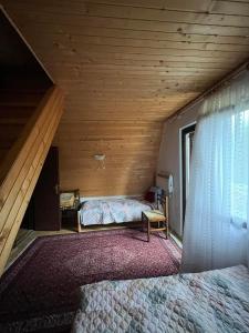 an attic bedroom with a bed and a window at Kuća Janjic Jahorina in Jahorina