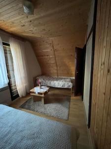 a bedroom with a bed and a bench in a wooden ceiling at Kuća Janjic Jahorina in Jahorina
