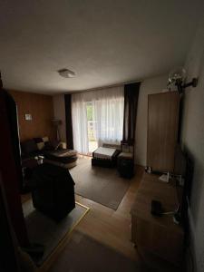 a living room with a couch and a window at Kuća Janjic Jahorina in Jahorina +4 photos