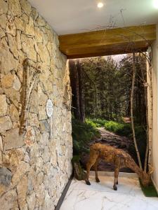 a stone wall with a statue of a horse in a doorway at Hotel Victor in Rialp