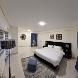 a bedroom with a large white bed and a rug at Byblos Prime in Aqaba