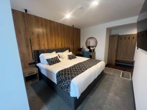 1 dormitorio con 1 cama grande y paredes de madera en Hotel NIKS, en Sevlievo