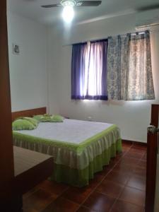 1 dormitorio con 2 camas y ventana en Canto do Forte da Ivone, en Praia Grande