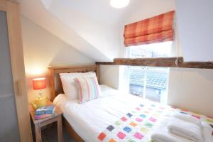 オールドバラにある6 Town Steps, Aldeburghの小さなベッドルーム(ベッド1台、窓付)