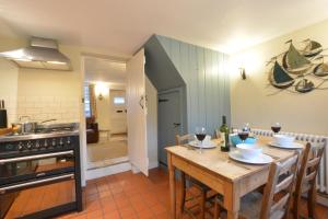 オールドバラにある6 Town Steps, Aldeburghのキッチン(木製テーブル、ワイングラス付)