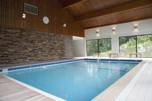 a swimming pool in a building with a brick wall at Résidence La Marmottane in Aime +6 photos