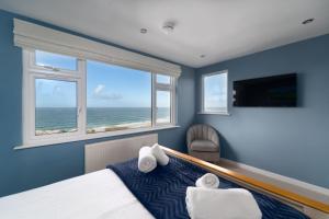 a bedroom with blue walls and a bed with towels at Porthmeor View in St Ives