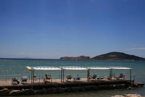 a dock with chairs and tables on the water at Villa Irlanda Grand Hotel in Gaeta