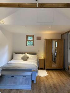 ein Schlafzimmer mit einem großen Bett und Holzboden in der Unterkunft Cosy 1 bedroom country lodge with free parking in Watlington