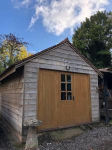 a small wooden shed with a door on it at Cosy 1 bedroom country lodge with free parking in Watlington