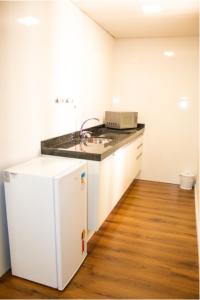 uma cozinha com um frigorífico branco e uma bancada em Golden Ingá Hotel em Maringá