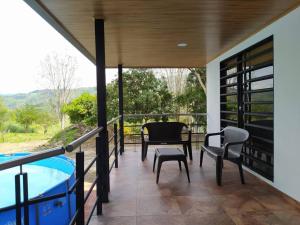 un patio con mesa, sillas y piscina en Cueva los Armadillos Lodge, Cabaña, Piscina, Inte., 