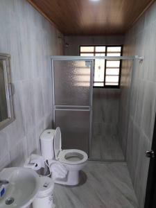 y baño con ducha, aseo y lavamanos. en Cueva los Armadillos Lodge, Cabaña, Piscina, Inte., 