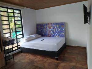 1 dormitorio con 1 cama con una pintura en la pared en Cueva los Armadillos Lodge, Cabaña, Piscina, Inte., 